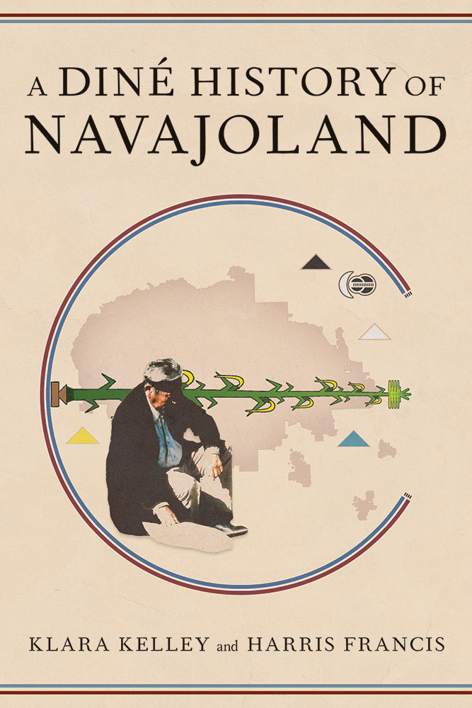 A Navajo Medicine man wearing a black headband is sitting with a map of the current borderlines of the Navjo Nation behind him. Around the map of the navajo nation are the four sacred mountains